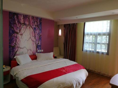 安顺尚客优酒店贵州安顺黄果树风景名胜区店的一间卧室设有一张大床和一个窗户。
