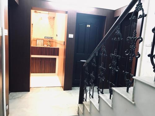 古鲁瓦尤尔LAKSHMI TOURIST HOME的走廊上设有黑色的门和楼梯