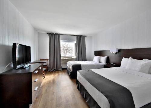 蒙特利尔Hotel Newstar Montréal的酒店客房设有两张床和一台平面电视。