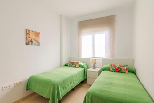 巴尔巴特Apartamentos Montedunas的带窗户的客房内的两张绿色床