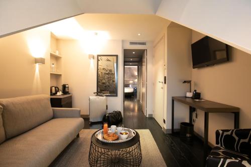 巴黎乐格雷酒店的客厅配有沙发和桌子