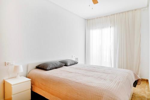 奥里韦拉Playamarina II Rooftop Apartment的白色的卧室设有床和窗户