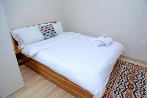 卢萨卡Troy Lodge的一张带白色床单和枕头的床