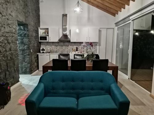 七城GRANARY'S HOUSE的一间带蓝色沙发的客厅和一间厨房