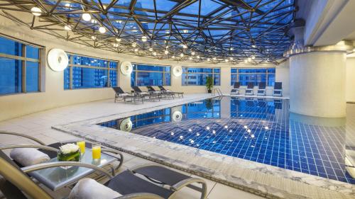 上海上海锦江汤臣洲际大酒店的一个带椅子和桌子的大型室内游泳池