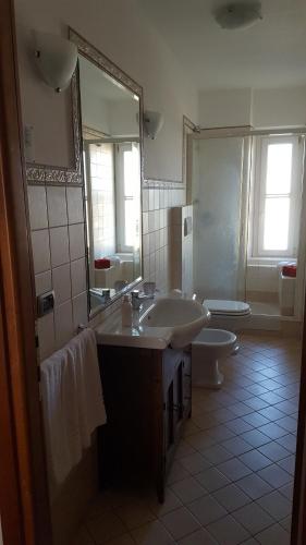 菲乌米奇诺Pisicchio Rooms的一间带水槽、卫生间和镜子的浴室