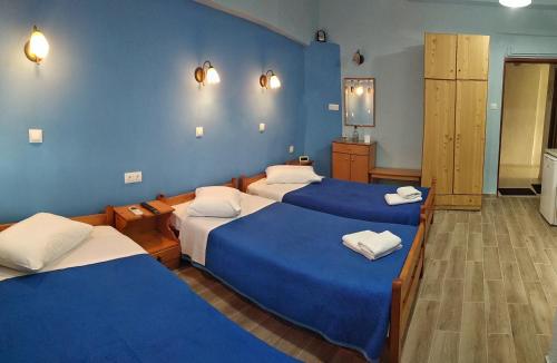 欧拉努波利斯Prosforio的带三张床和蓝色墙壁的客房