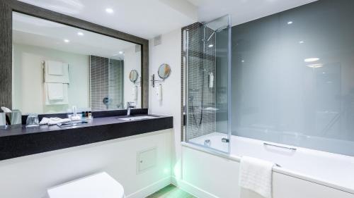 斯劳假日斯劳温莎酒店度假村的带淋浴、盥洗盆和镜子的浴室