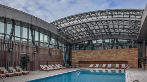 滨海新区天津于家堡洲际酒店及行政公寓的一座带玻璃天花板的建筑中的游泳池