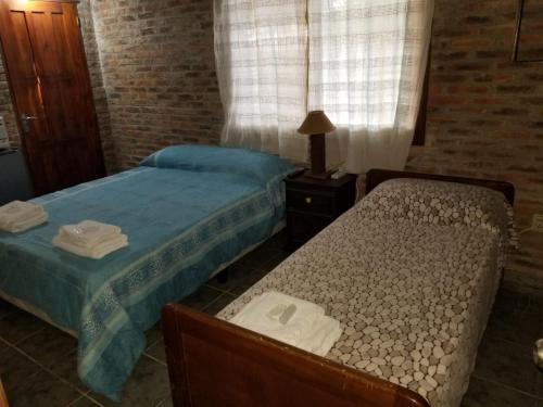 特立尼达岛Hospedaje lo de la Ñata的一间卧室配有两张床,还有一个床头柜和床架