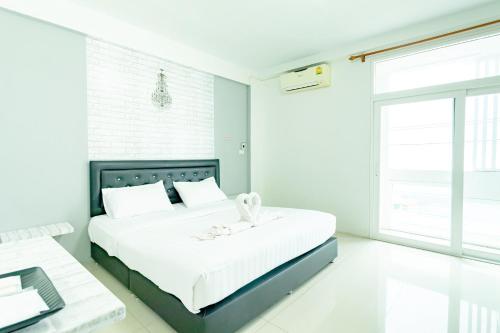 合艾中央景观旅馆的白色卧室配有一张大床和一张书桌