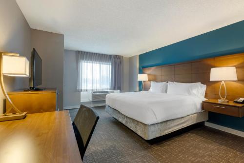 奥兰多Staybridge Suites Orlando Royale Parc Suites, an IHG Hotel的酒店客房设有一张大床和一张书桌。