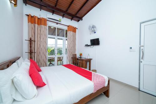 康提Dazzling Villa的一间卧室配有一张带红色枕头的床和一扇窗户