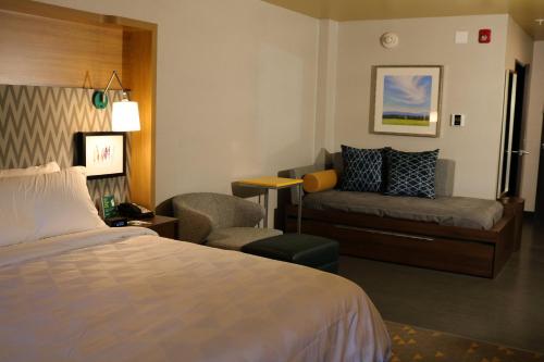 琼斯伯勒Holiday Inn - Jonesboro, an IHG Hotel的酒店客房,配有床和沙发
