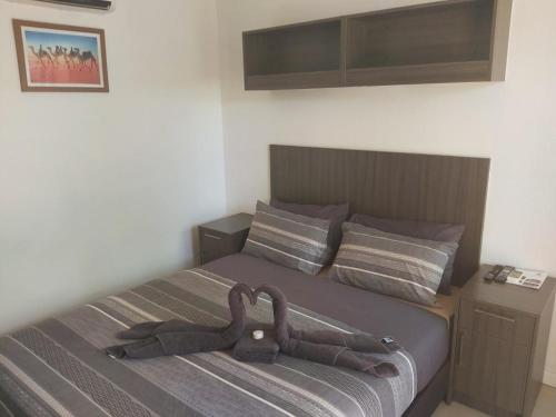 纽曼摩羯村酒店的一间卧室配有一张带棕色床头板的床