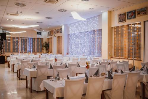 Trebnje特雷布涅银河酒店的宴会厅配有白色的桌椅