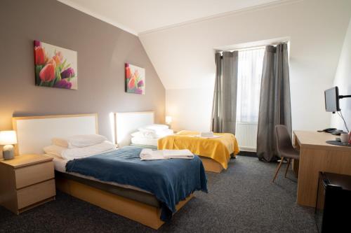 科希策泰勒德姆酒店的酒店客房配有两张床和一张书桌