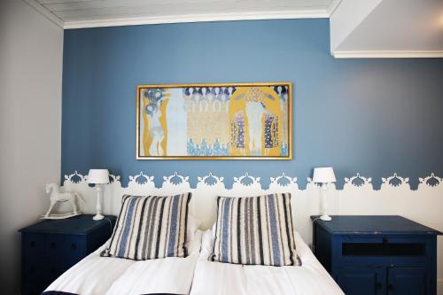 于韦斯屈莱尤普精品酒店的一间卧室设有蓝色的墙壁和一张带条纹枕头的床