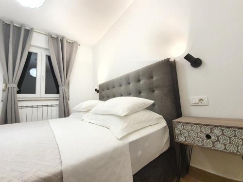 比比涅Apartments Karla的卧室配有白色的床和窗户。