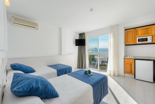 伊维萨镇Apartamentos Vibra Panoramic的酒店客房设有三张床和阳台