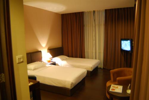 哥打京那巴鲁芒亚酒店的酒店客房设有两张床和电视。