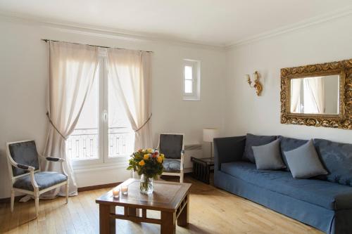 巴黎密斯豪德公寓式酒店的客厅配有蓝色的沙发和桌子