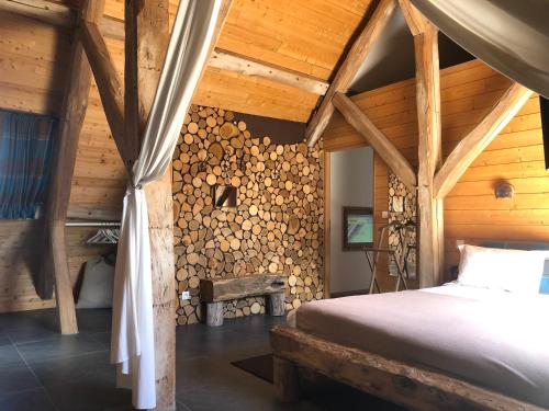AuthouilletLa Ferme des Isles的一间卧室设有一张床和一堵木墙