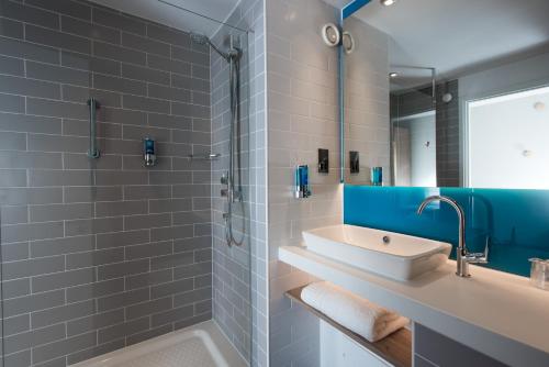 朴次茅斯Holiday Inn Express Portsmouth – North, an IHG Hotel的一间带水槽、浴缸和镜子的浴室