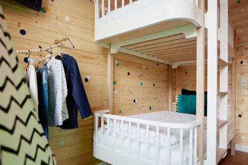 科隆朋友酒店的儿童间设有木墙和一张双层床