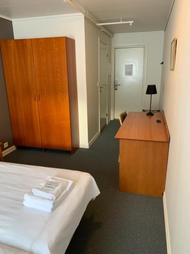 纳尔维克Narvik Budget Rooms的客房设有一张床、一张书桌和橱柜。