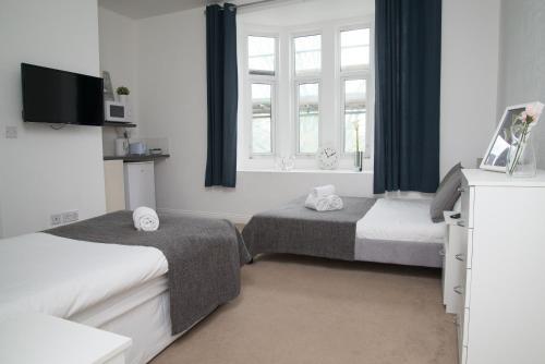 伦敦TLK Apartments & Hotel - Beckenham Junction的一间卧室设有两张床和窗户。