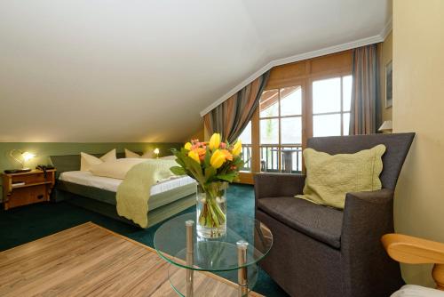 巴特法伊尔恩巴赫Hotel zum Maximilian的一间卧室配有一张床、花瓶和椅子
