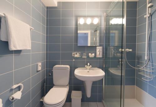 巴德茨韦斯滕Hotel Kavaliershaus/Schloss Bad Zwesten的蓝色瓷砖浴室设有卫生间和水槽