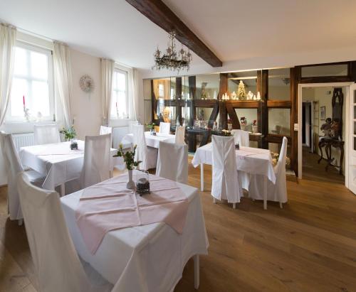 巴德茨韦斯滕Hotel Kavaliershaus/Schloss Bad Zwesten的用餐室配有白色的桌子和白色的椅子