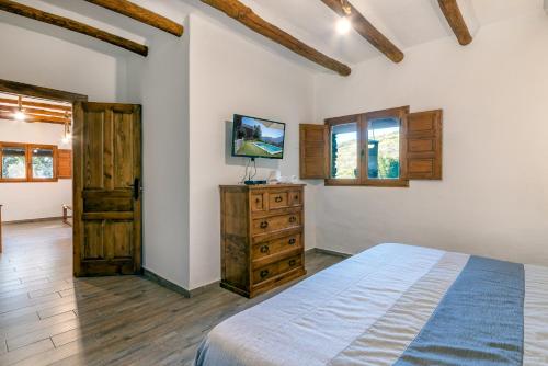 潘潘埃拉Dreams Alpujarra的一间卧室配有一张床、梳妆台和窗户。
