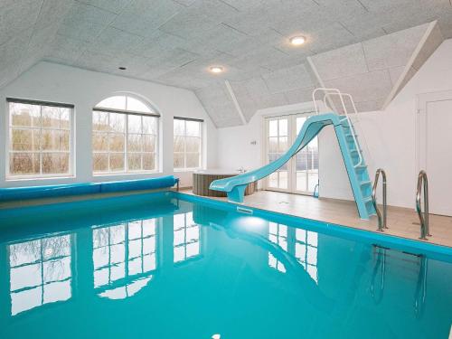 乌尔夫堡16 person holiday home in Ulfborg的大楼内一个带滑梯的游泳池