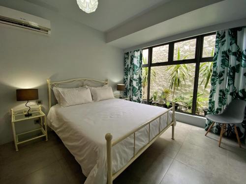 塔马兰Under The Tropics的一间卧室设有一张床和一个大窗户
