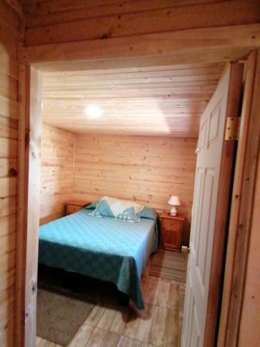 埃尔基斯科Cabaña sol y luna的小木屋内一间卧室,配有一张床