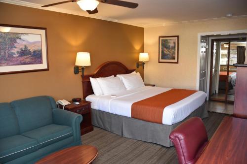 雷德兰兹雷德兰兹王朝套房酒店的酒店客房配有床、沙发和椅子