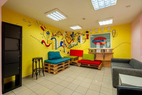索非亚Smart Hostel Sofia的一间设有彩色椅子和涂鸦墙的等候室