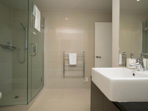 陶波Marinaside Villa - Taupo Holiday Apartment的一间带水槽和淋浴的浴室