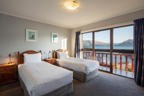 皇后镇Matterhorn Lodge的酒店客房设有两张床和一个阳台。