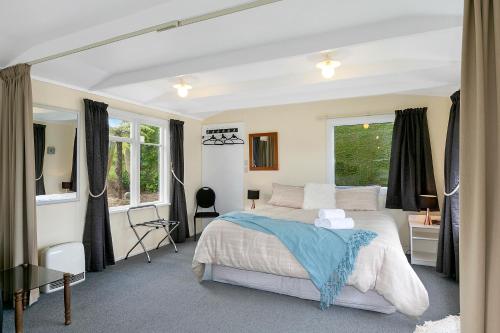 Company BayMacbay Retreat - Macandrew Bay Holiday Home的一间卧室设有一张大床和一个窗户。