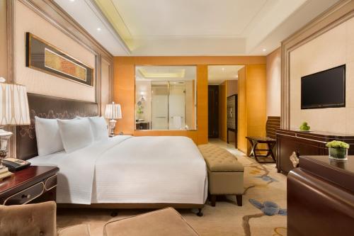 哈尔滨哈尔滨富力万达嘉华酒店的酒店客房设有一张大床和一台电视。