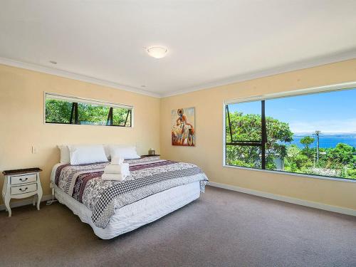 陶波Acacia Bay Getaway - Lake Taupo Holiday Home的一间卧室设有一张大床和一个大窗户