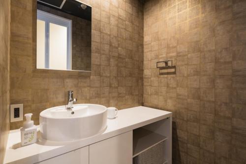 北九州GRAND BASE Moji Nagomi的浴室设有白色水槽和镜子