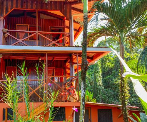 德雷克Las Caletas Lodge的一座种植了棕榈树的橙色建筑