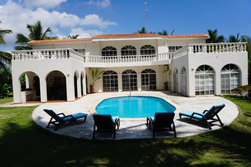 卡布雷拉Baoba Breeze Bed & Breakfast- beachfront paradise的一座带游泳池和椅子的大型白色房屋