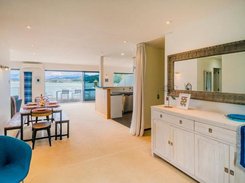 怀蒂昂格Seaview Serenity- Whitianga Holiday Home的厨房、带桌子的客厅和用餐室