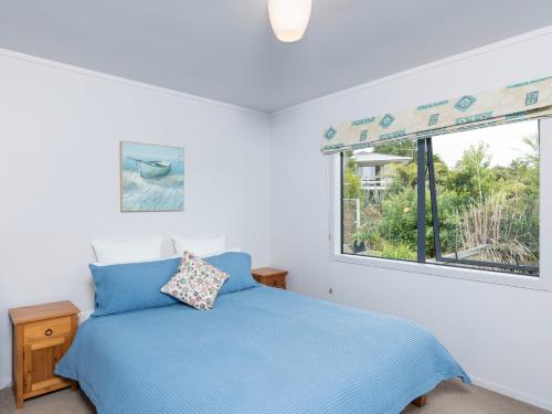 OpuaSkipper's Haven - Opua Holiday Home的一间卧室设有蓝色的床和窗户。